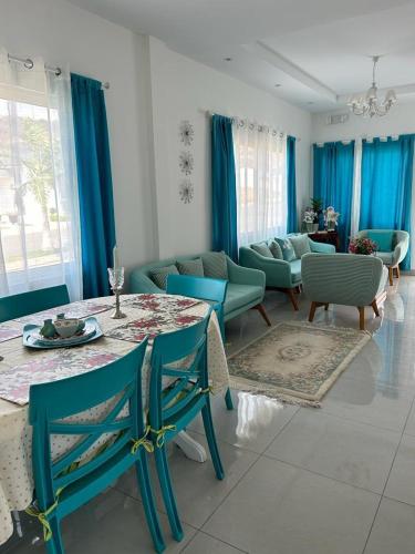 Una sala de estar con una mesa y sillas azules. en Pacific Coastal Cabin Shelter, en San Jacinto