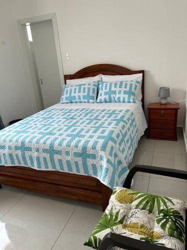 Un dormitorio con una cama con un edredón azul y blanco. en Pacific Coastal Cabin Shelter, en San Jacinto