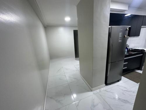 Eine Küche mit einem Edelstahlkühlschrank auf Fliesenboden in der Unterkunft cop 30 in Belém