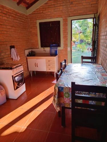 ein Zimmer mit einem Bett und einem Ofen und einem Fenster in der Unterkunft Chalés e Camping 4 Estações in São Thomé das Letras