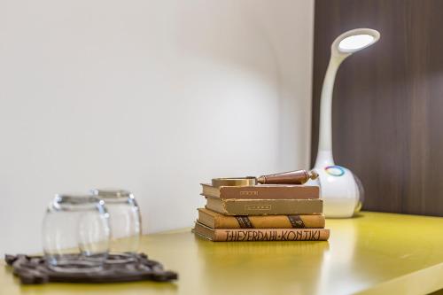 a stack of books sitting on a table next to a lamp at Piano Nobile Rooms in Split
