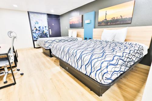 a bedroom with a bed and a desk in it at West Texas Inn & Suites with Kitchenette in Midland