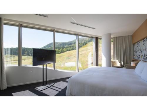 a bedroom with a bed and a flat screen tv at Skye Niseko - Vacation STAY 30728v in Niseko