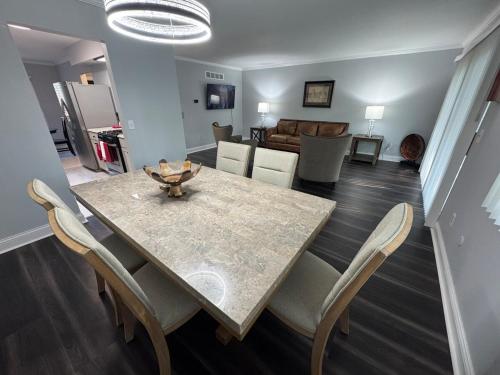 a dining table and chairs in a living room at Suburban Retreat 15 Mins to Downtown Detroit in Southfield