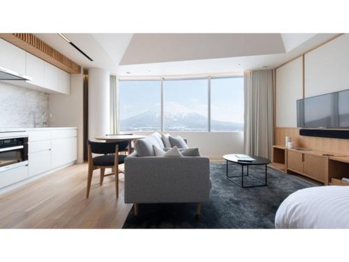 a living room with a couch and a bed and a table at Skye Niseko - Vacation STAY 30764v in Niseko