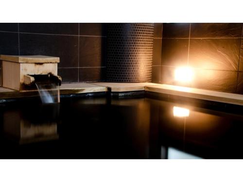 a bathroom with a tub with a light on the wall at Skye Niseko - Vacation STAY 30771v in Niseko