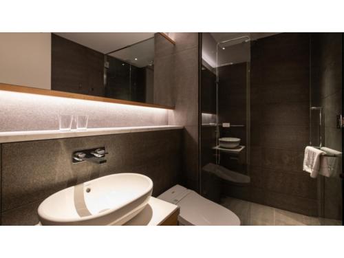 a bathroom with a toilet and a sink and a mirror at Skye Niseko - Vacation STAY 41541v in Niseko