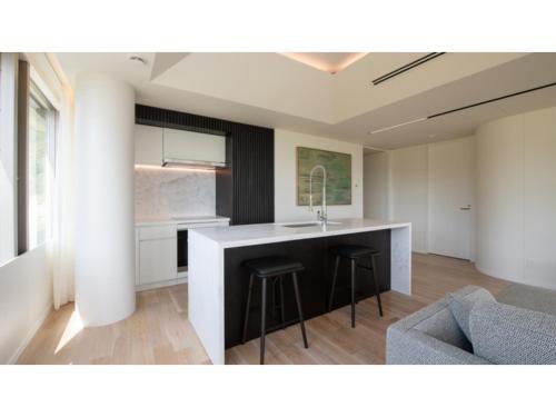 a kitchen with a counter and two bar stools at Skye Niseko - Vacation STAY 41541v in Niseko