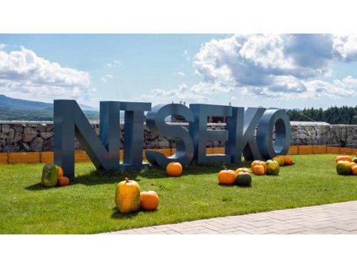 a large sign in the grass with pumpkins on the grass at Skye Niseko - Vacation STAY 70567v in Niseko
