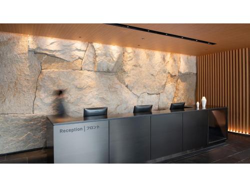 a lobby with a stone wall and a reception desk at Skye Niseko - Vacation STAY 70578v in Niseko