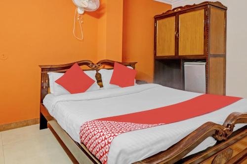 a bedroom with a large bed with red pillows at Hotel O Royal Grand Residency Near Lalbagh Botanical Garden in Bengaluru