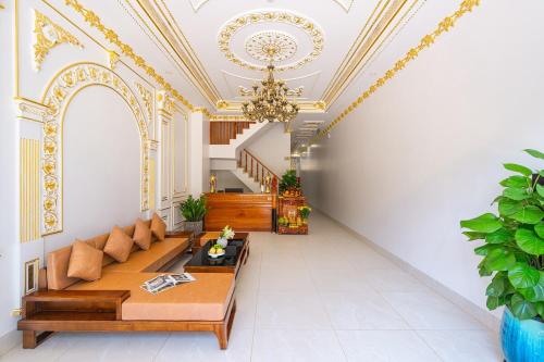 a living room with a couch and a chandelier at Homestay Song Ngọc in Ấp Sung Xuân