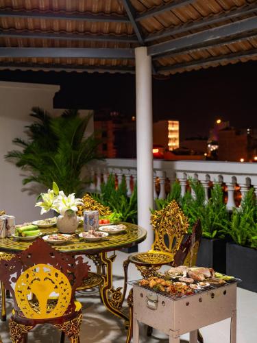 a table and chairs with food on a balcony at Homestay Song Ngọc in Ấp Sung Xuân