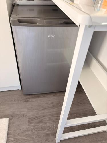 a dishwasher sitting next to a white desk at Modern En-Suite Double Bedroom in Cardiff with Private Entrance in Cardiff