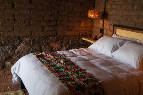Miahuatlán de Porfirio DíazにあるCasa Xaguarのレンガの壁のある部屋にあるベッド