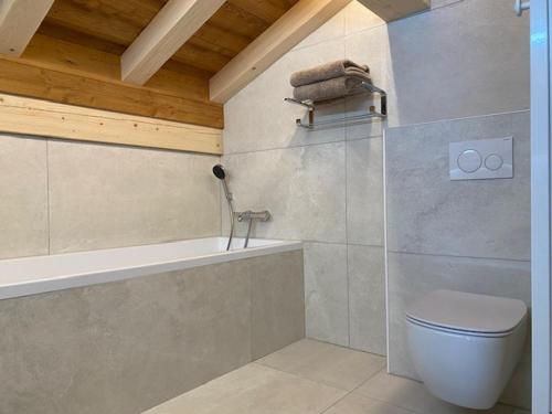 une salle de bain avec toilettes et baignoire dans l'établissement Chalet luxueux aux Gets, 4 chambres, sauna, parking privatif - FR-1-671-305, aux Gets