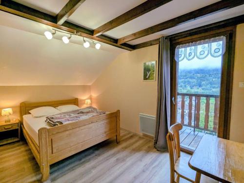 ein Schlafzimmer mit einem Bett und einem großen Fenster in der Unterkunft Chalet familial dans le Parc des Vosges, wifi et animaux acceptés - FR-1-589-840 in Le Ménil