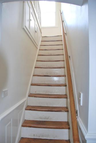 a stairway with white walls and wooden stairs at Islay House - Blue Room in Woodend