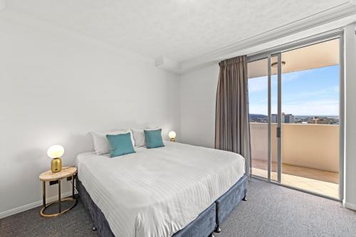a bedroom with a bed and a large window at CLLIX Brisbane Central Apartments in Brisbane