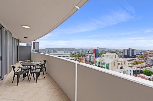 a balcony with a table and chairs and a view at CLLIX Brisbane Central Apartments in Brisbane