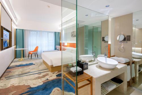a bathroom with a bed and a sink in a room at Landmark International Hotel - Grandview Mall in Guangzhou