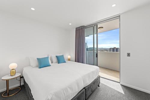 a bedroom with a large bed and a balcony at CLLIX Brisbane Central Apartments in Brisbane
