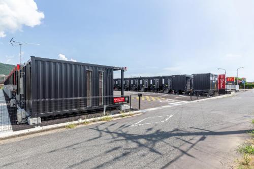 a row of black containers on the side of a road at HOTEL R9 The Yard Sagakashima in Kashima