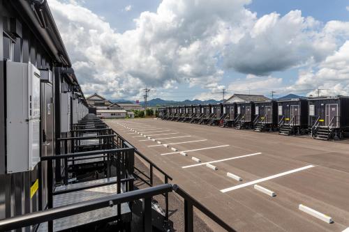 an empty parking lot with a row of terminals at HOTEL R9 The Yard Sagakashima in Kashima