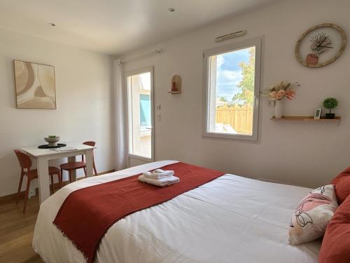 a bedroom with a bed and a table and a window at Gîte Cosy TY CLEM cottage in Mouilleron-le-Captif