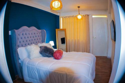 ein Schlafzimmer mit einem weißen Bett mit einem roten Ball drauf in der Unterkunft Departamento de Ensueño in Huaraz