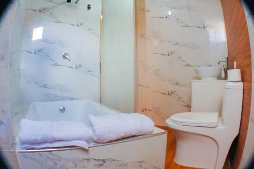 ein Badezimmer mit einer weißen Badewanne und einem WC in der Unterkunft Departamento de Ensueño in Huaraz