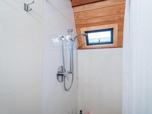 a shower in a bathroom with a window at The Sorting Hat - Pauanui Holiday Home in Pauanui