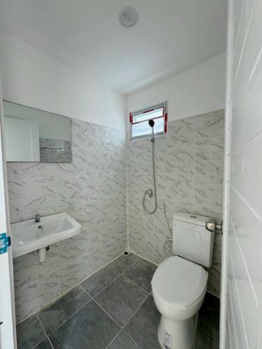 a bathroom with a toilet and a sink at RT House Resort in Ban Phawon
