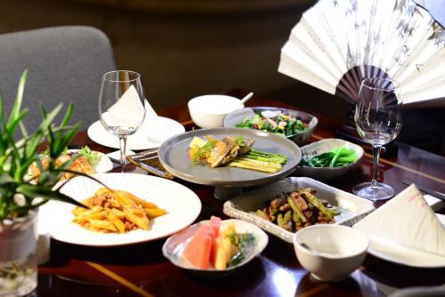 a table with plates of food and glasses of wine at Crowne Plaza Yichang by IHG in Yichang