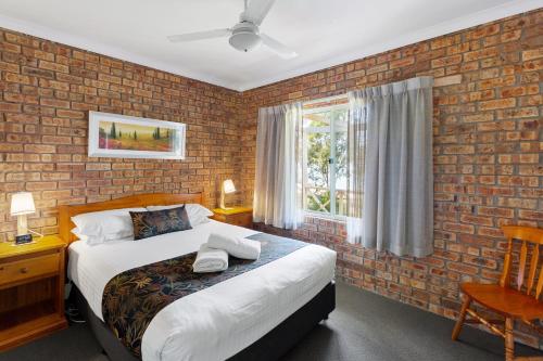 Un dormitorio con una cama y una pared de ladrillo. en Mansfield Country Resort, en Mansfield