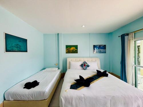 two beds in a room with blue walls at Aoonilay Resort Chaam-Huahin Zone B in Ban Bang Sai Yoi