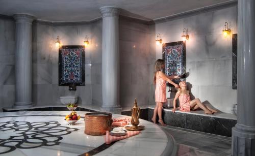 a woman in a bathroom with a child in a tub at Aquasis De Luxe Resort & SPA - Ultra All Inclusive in Didim