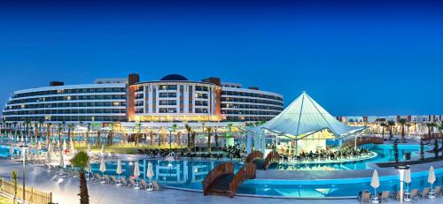 duży budynek z basenem przed nim w obiekcie Aquasis De Luxe Resort & SPA - Ultra All Inclusive w mieście Didim