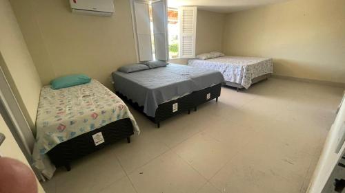 a bedroom with two beds and a window at Casa Beach park in Aquiraz