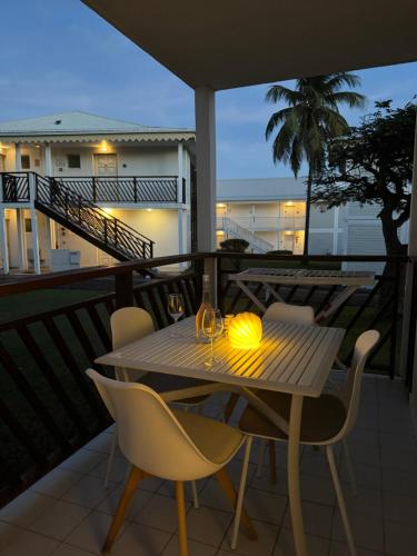 a table and chairs on a balcony at night at Morphée Lodge in Saint-François