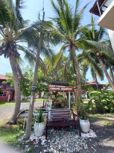 un parco con panchina e palme di Homestay Cenang Village Langkawi a Pantai Cenang
