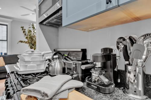 a kitchen counter with a sink and a stove at Elegant 3BR-2BA in Gramercy -Modern & Central in New York