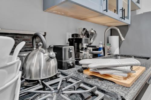 a kitchen counter with a tea kettle on a stove at Elegant 3BR-2BA in Gramercy -Modern & Central in New York
