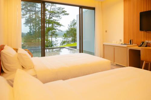 a hotel room with two beds and a large window at Haven in the Pines in Ðinh An (2)