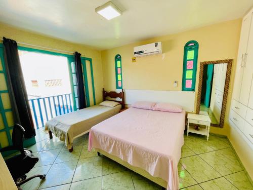 a bedroom with two beds and a mirror at Morada do Mar Arraial do Cabo in Arraial do Cabo