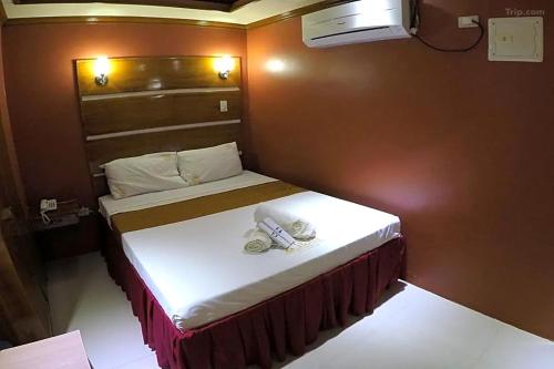 a small bedroom with a bed with towels on it at Taj Hotel Tuguegarao in Tuguegarao City