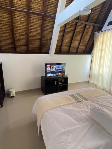 ein Schlafzimmer mit einem Bett und einem Flachbildfernseher in der Unterkunft Blackstone Paradise in Bumbang