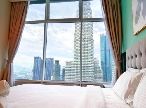 a bedroom with a large window overlooking a city at Sky Suites KLCC Luxury Homestay in Kuala Lumpur