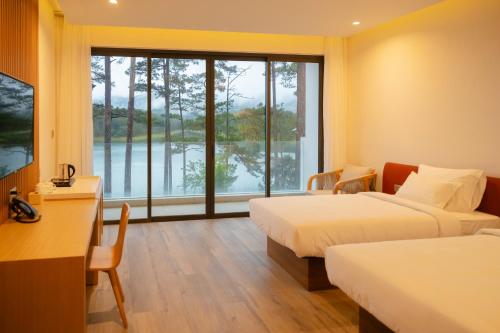 a hotel room with two beds and a large window at Haven in the Pines in Ðinh An (2)