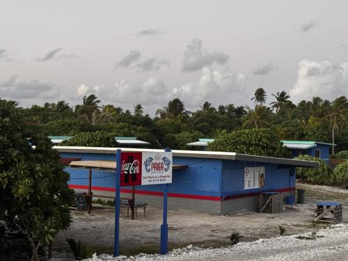 Un edificio azul con un cartel delante. en Dream lodge II, en Rangiroa